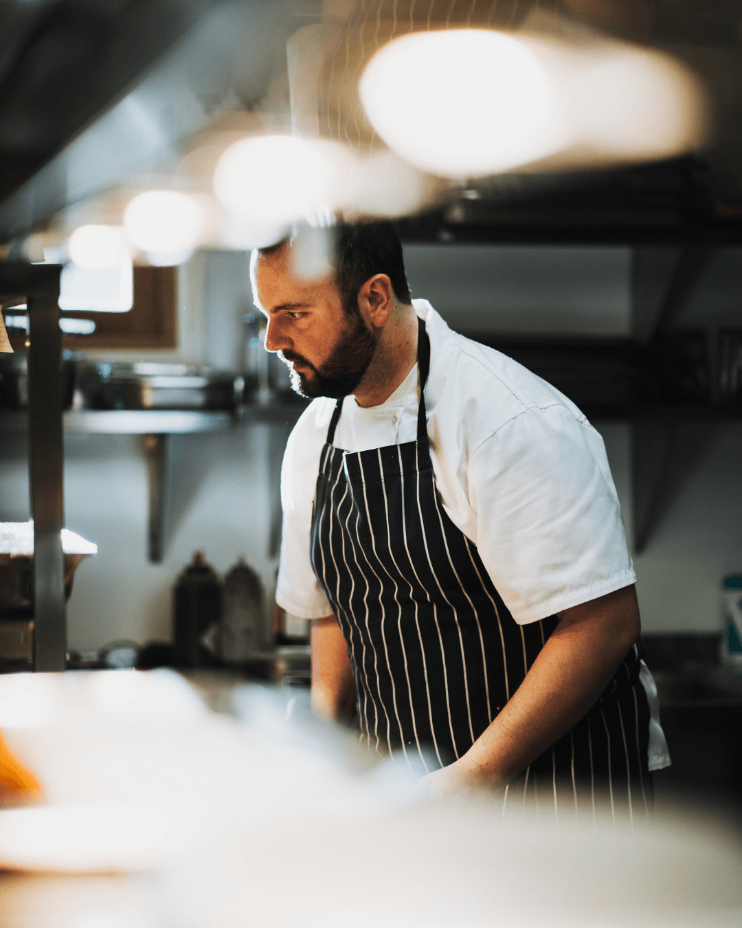 Sous Chef Chris Wilcox concentrates as he prepares a dish for a Food Taster Event at Tower Hill Barns.