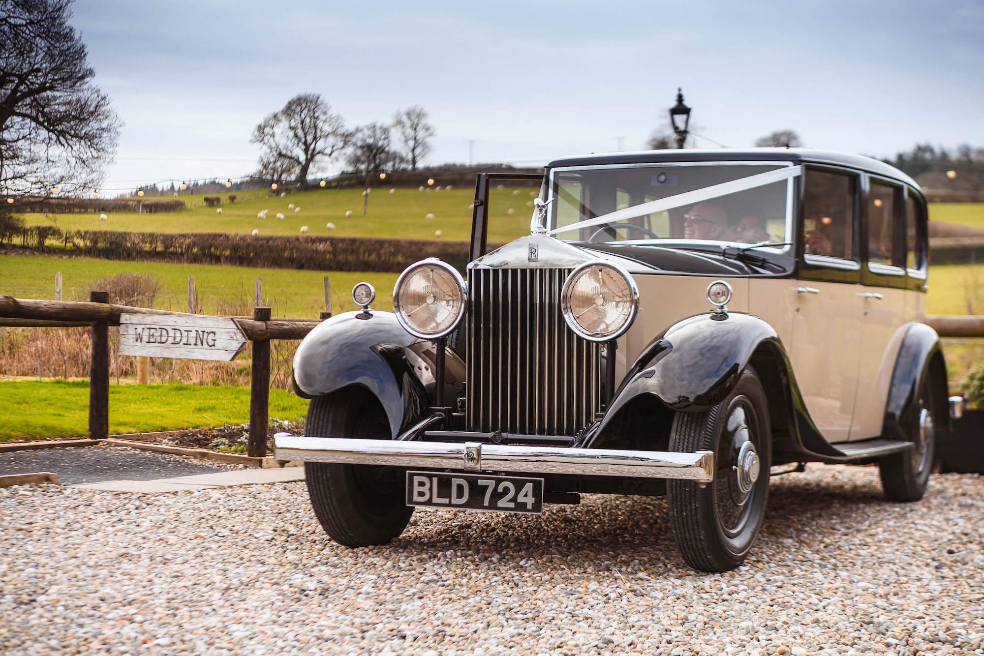 Newlyweds Emily & Ben drive through the Welsh Countryside in their wedding car, a Rolls Royce following their church wedding.