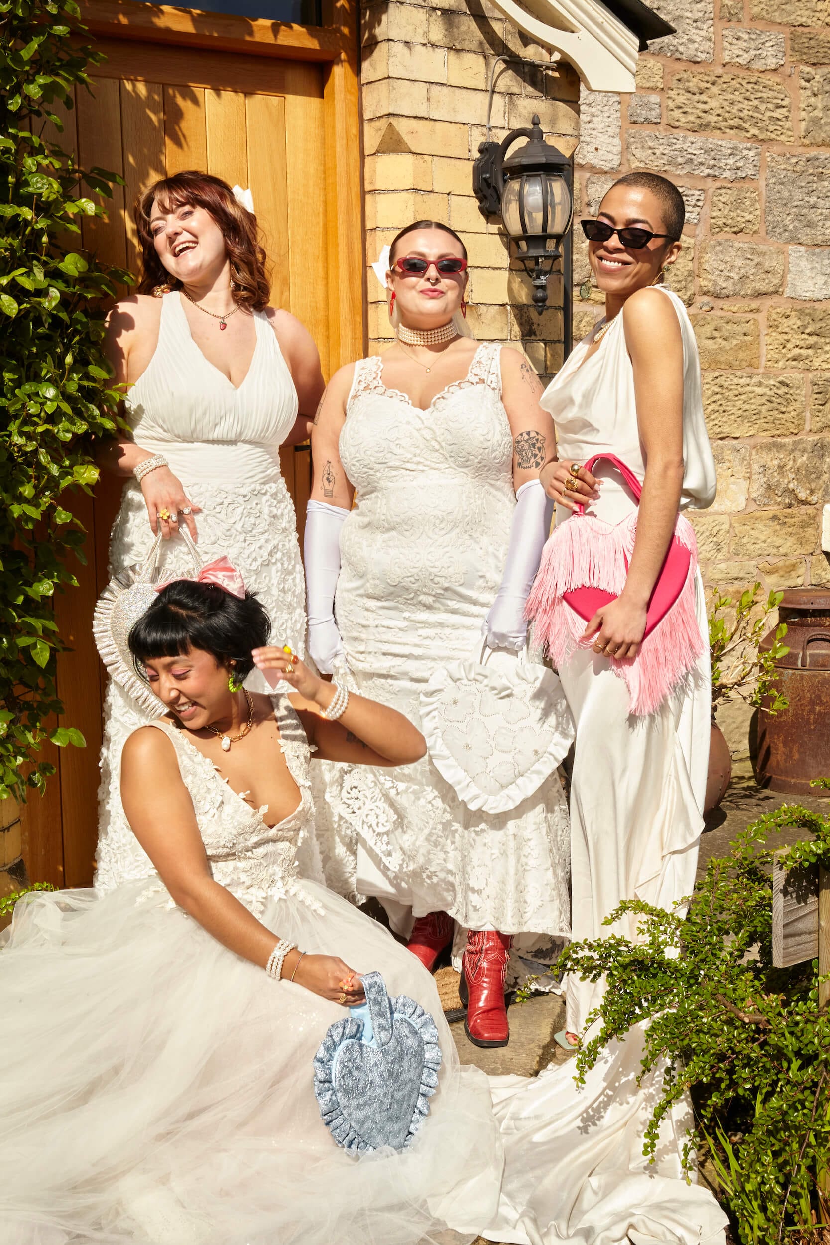 Inclusive, eco-conscious influencers pose wearing preloved bridal dresses outside the farmhouse at Tower Hill Barns for a sustainable-weddings styled shoot in collaboration with Barnardos.